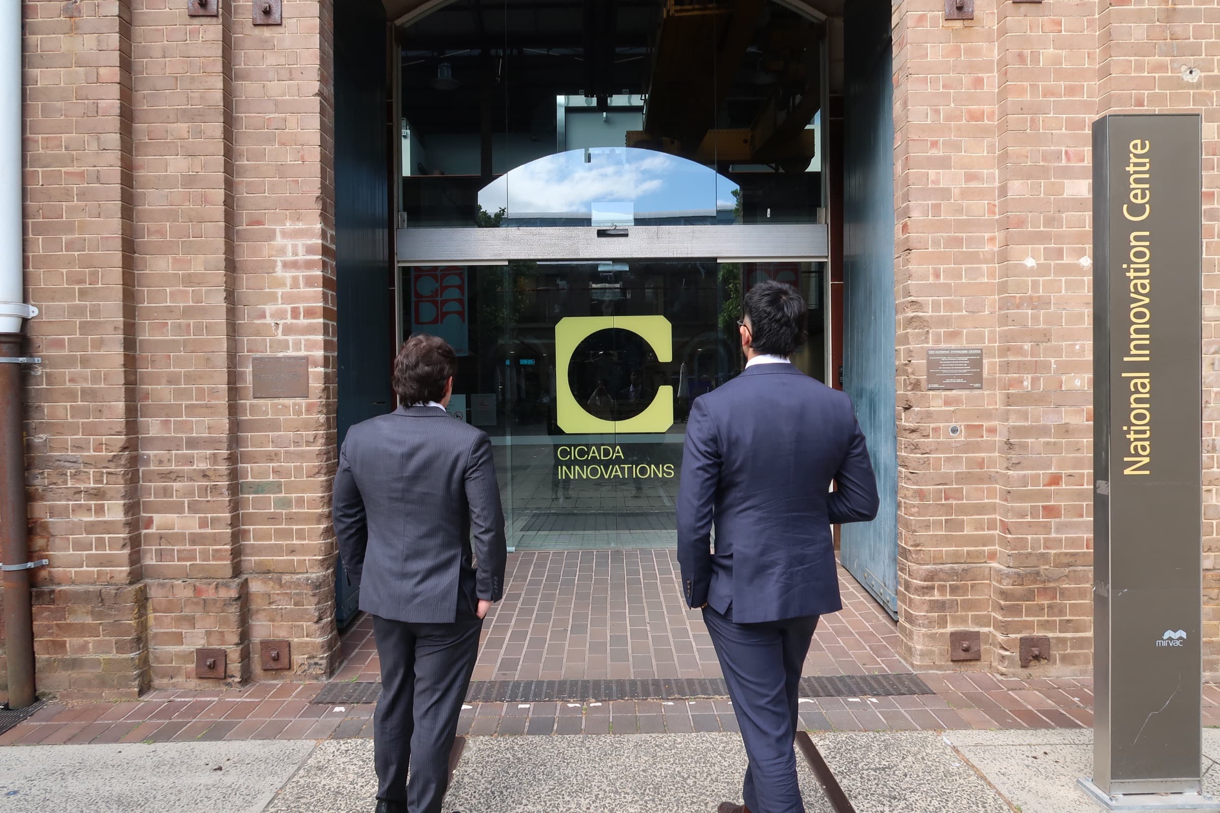 Two METASORB representatives approaching the Cicada Innovations entrance at the National Innovation Centre